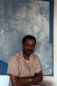 Murray in front of "With Blue" by Romare Bearden (1962), which hung above the Murrays' dining table for decades. © Estate of Albert Murray.