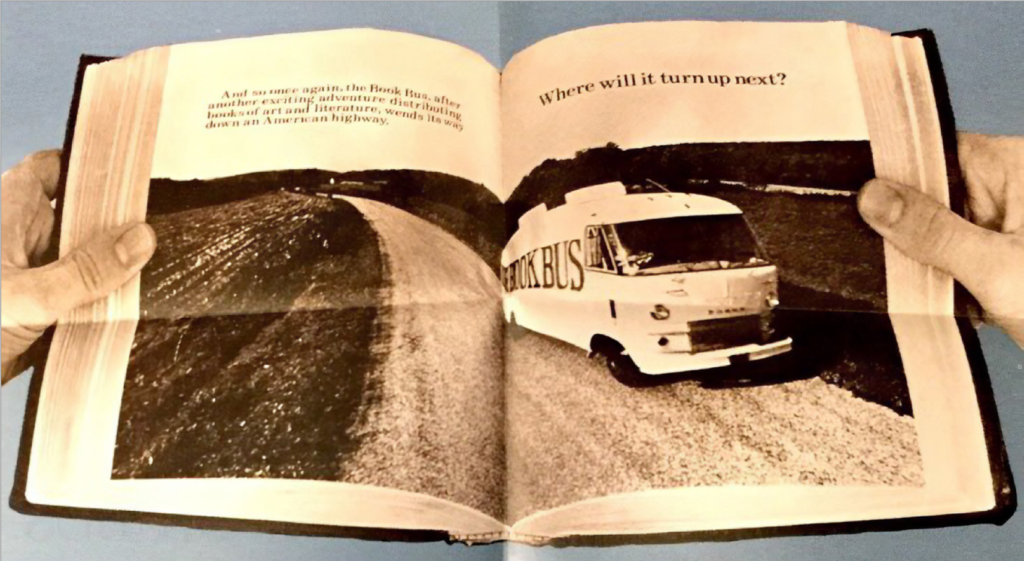 Person holding a book with a black and white photograph of a bookmobile.