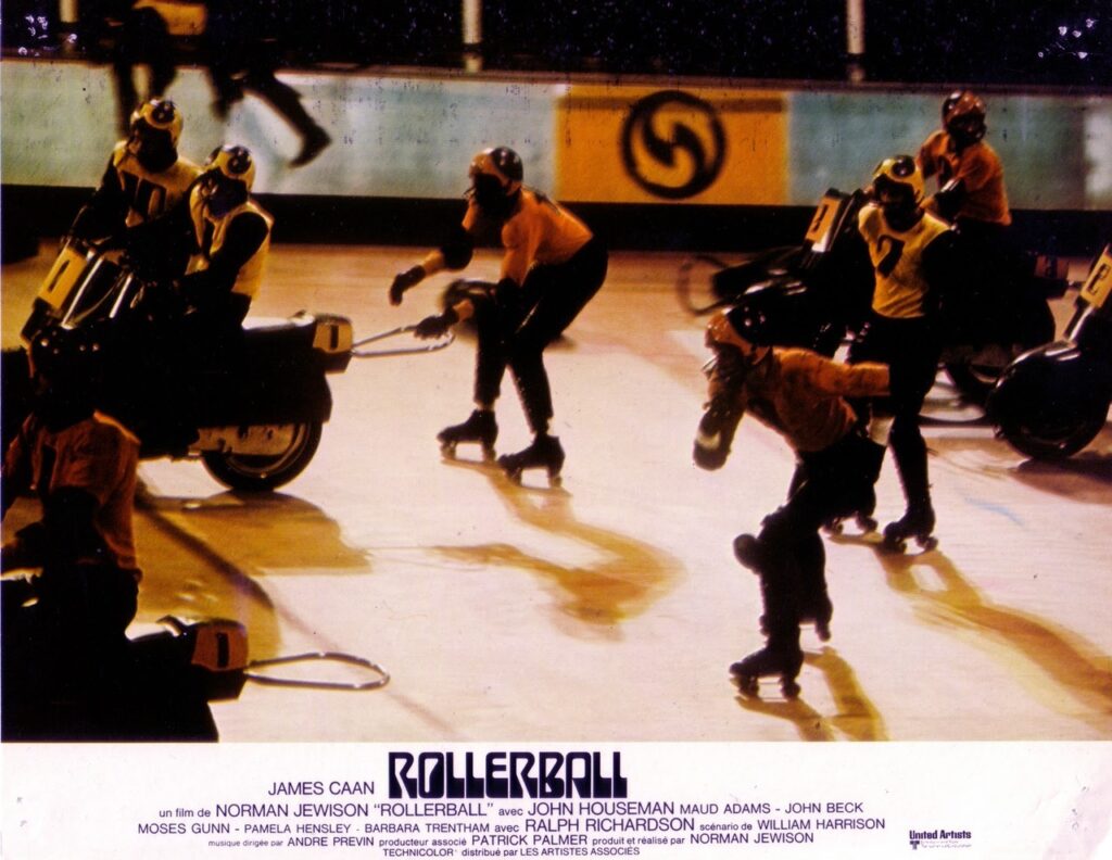 Scene from Rollerball; Jonathan E and skaters and motorcyclists in the rink.