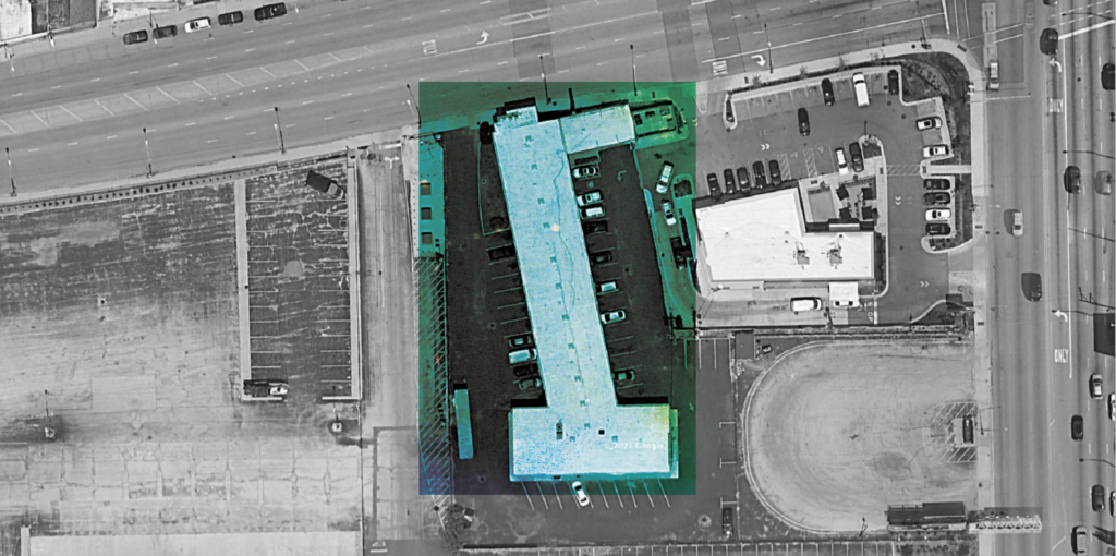 A black and white satellite image of a motel and the surrounding infrastructure. The motel is highlighted in an eerie green.